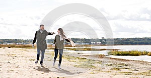 Couple running along autumn beach