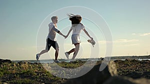 Couple running along the rocks on promenade