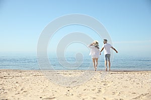 Couple running on beach near sea. Honeymoon trip