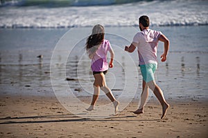 Couple running on beach. Running people jogging on beach exercising and jogging training. Sport runners working out on