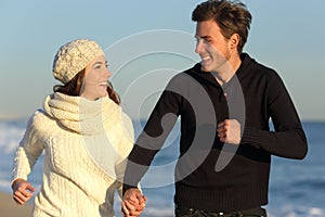 Couple running on the beach in winter