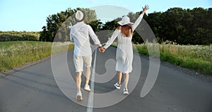 Couple Running on Countryside Road Backview
