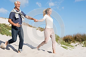 Couple running down dune