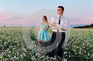 Couple running in field holding hands.