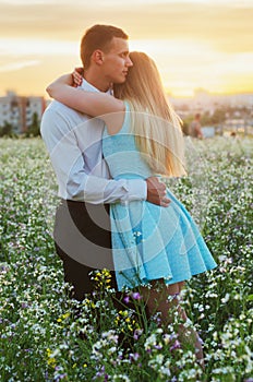 Couple running in field holding hands.