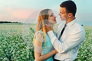 Couple running in field holding hands.