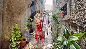 Couple running through old buildings. Tourists, enjoying summer holiday together. European city. Holiday, date, love, lifestyle