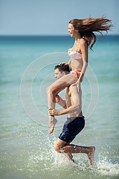 Couple running on a tropical beach. Vacation