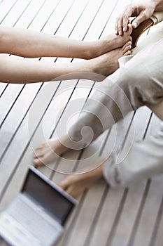 Couple's Feet With Laptop On Floor