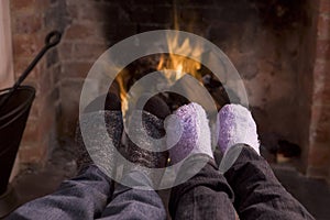 Couple's feet warming at a fireplace