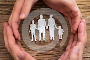 Couple`s Hand Protecting Family Figures