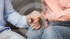 couple's hands holding each other, woman wearing ring indoor, closeup