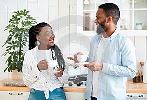 Couple's Daily Life. Happy Black Man And Woman Drinking Coffee In Kitchen