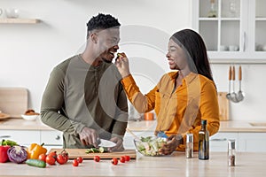 Couple's Lifestyle. Romantic Black Man And Woman Cooking Food In Kitchen Together