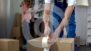 Couple sadly watching worker taking away their things, confiscation of property