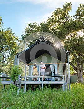 couple on safari in South Africa, Asian women and European men at a tented camp lodge during safari