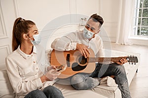 couple in safety masks playing musical