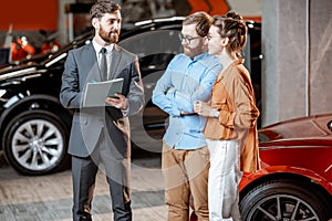 Couple with sales manager in the car dealership