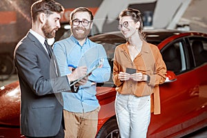 Couple with sales manager in the car dealership