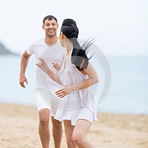 Couple on sand seashore in cloudy day