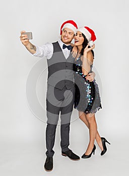 Couple in santa hats aking selfie at christmas