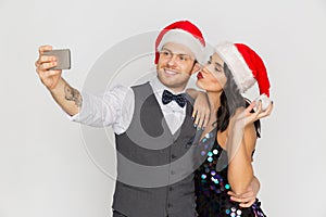 Couple in santa hats aking selfie at christmas