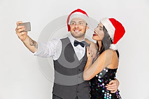 Couple in santa hats aking selfie at christmas