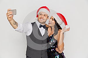 Couple in santa hats aking selfie at christmas