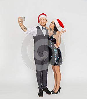 Couple in santa hats aking selfie at christmas