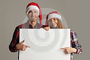 Couple in Santa hats with banner