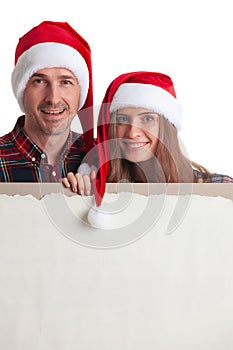 Couple in Santa hats with banner
