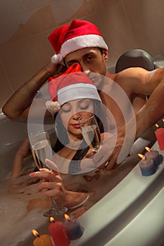 Couple in santa hats is enjoying a bath