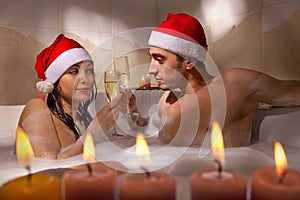 Couple in santa hats is enjoying a bath