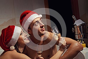 Couple in santa hats is enjoying a bath