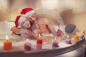 Couple in santa hats is enjoying a bath