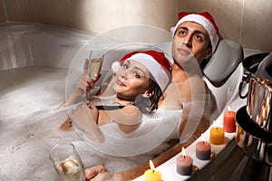 Couple in santa hats is enjoying a bath