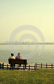 Couple sat on bench by lake photo