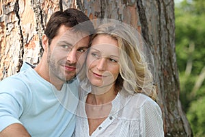 Couple sat in front of tree