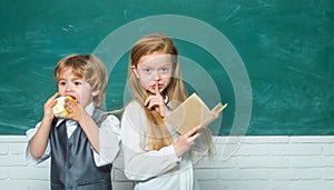 Couple of schoolgirl and schoolboy in Love together. Boy and girl from elementary school at the school yard. School