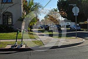 A couple of scooters on an L.A. corner waiting to be rented and ridden away.