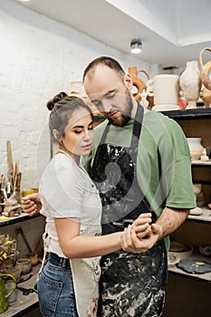 Couple of sculptors in aprons holding photo