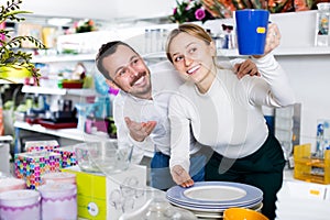 Couple selecting crockery in store