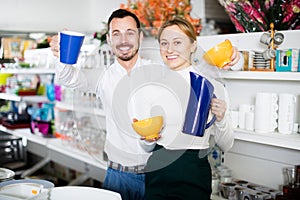 Couple selecting crockery in store