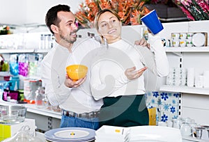 Couple selecting crockery in store