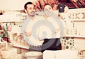 Couple selecting crockery in store