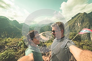 Couple selfie on mountain top at Nong Khiaw panoramic view over Nam Ou River valley Laos  travel destination in South East Asia,