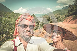 Couple selfie on mountain top at Nong Khiaw panoramic view over Nam Ou River valley Laos  travel destination in South East Asia,