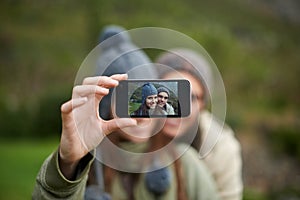 Couple, selfie and photo while hiking in nature, smartphone and capture moment in outdoors. People, happy and picture