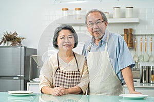 Couple senior Asian elder happy living in home kitchen. Grandfather hug grandmother with happiness and smile enjoy retirement life