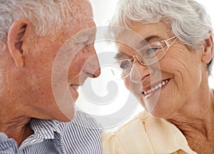 Couple, senior and happy or love in looking, home and relax together for bonding and smile. Elderly people, romance and